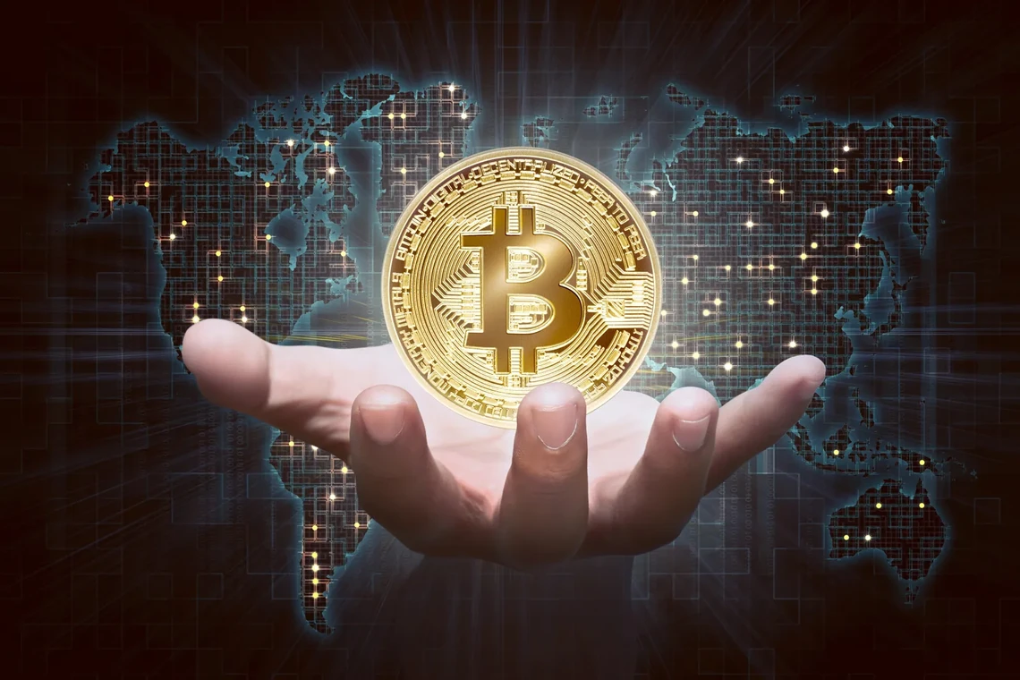 Golden bitcoin held in a hand